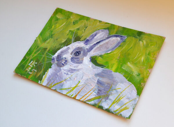One-of-a-kind acrylic painting "White bunny portrait" by Lada Kholosho (2025). Charming and vibrant artwork featuring a rabbit in lush green foliage. Perfect for wildlife art lovers and collectors. Ships worldwide
